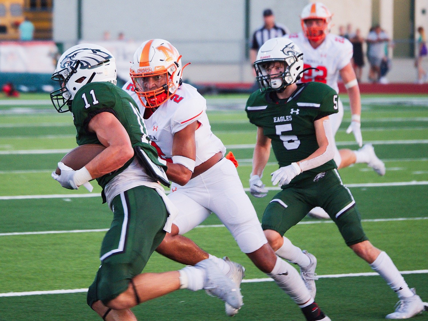 Mineola’s Jaxon Holland (2) pursues the Canton runner in Friday’s season opener, won 24-21 by the host Eagles. [more photos from Canton]
